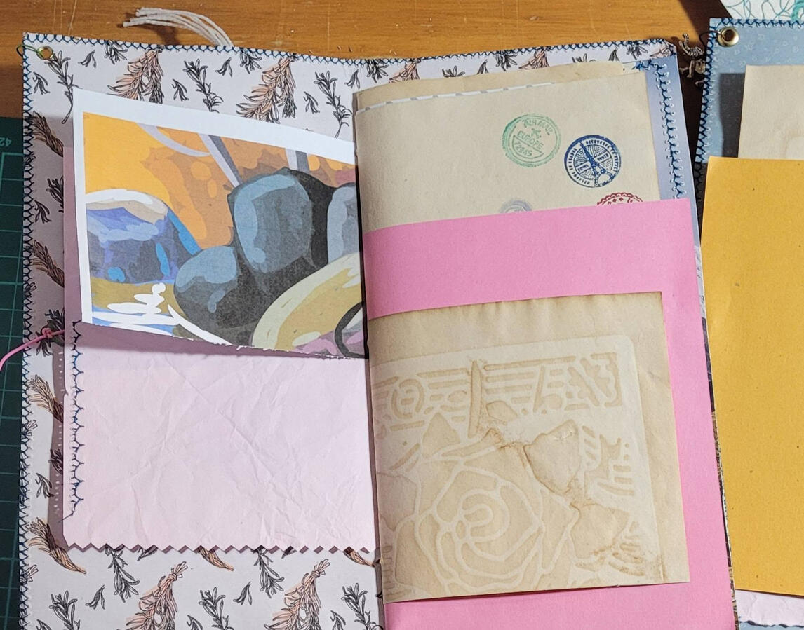 Just a little peek at some of the papers inside. When I dyed this coffee paper, I used the coffee to add some flower detail. And stamped some little stamp images in various colours.